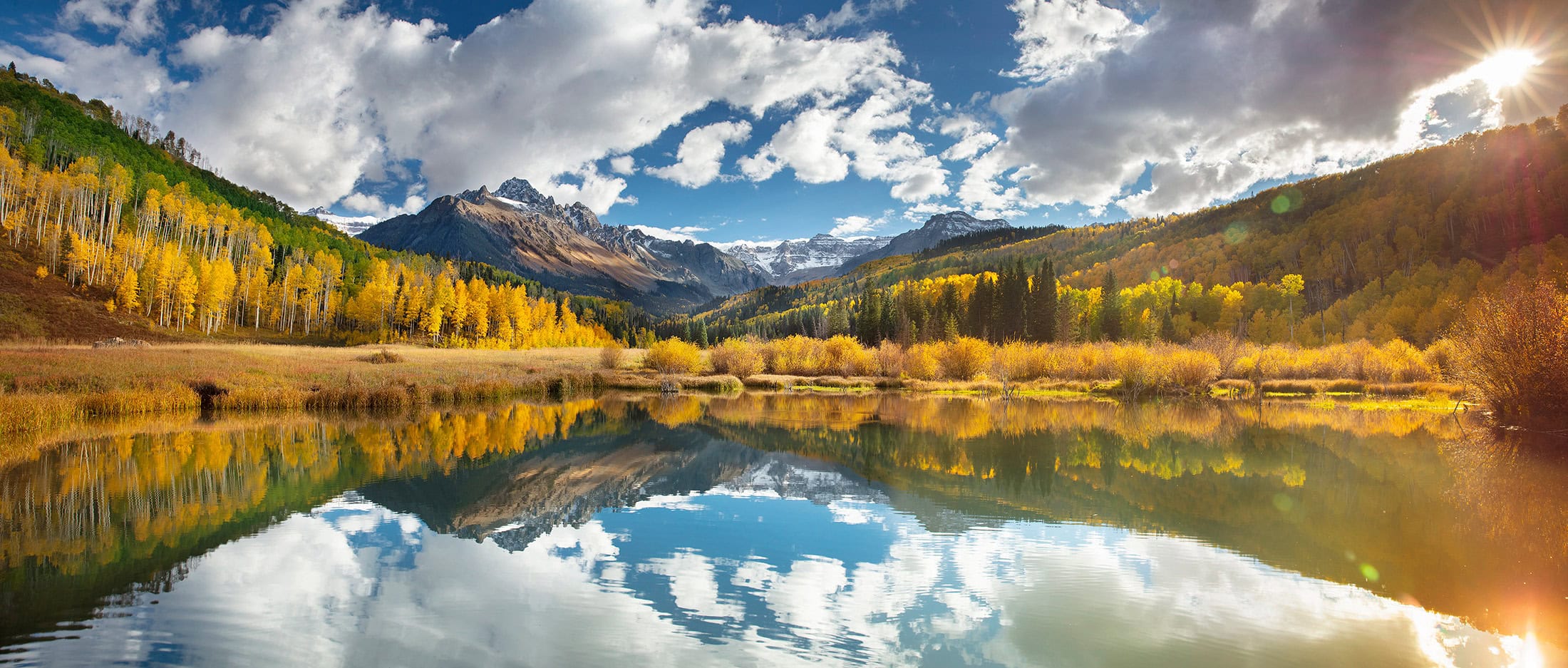 An unnamed mountain lake at first light, the range and cloud doubled in the water